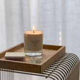 Boujie Solstice candle burning on marble tray with matches and glass decor, creating a calm and modern home atmosphere.